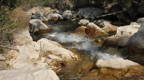 Creek bubbles merrily through the rocky terrain Stock Footage 40344256