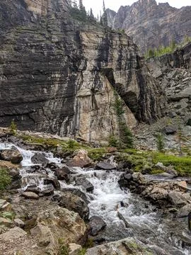 A creek flows down through textured rock in the mountains Stock Photos