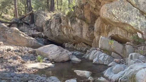 A Creek Flows Through Canyon of Smooth Boulders Видео 196942734
