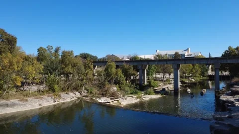 Creek River running under Bridge background buildings Stock Footage 321366805
