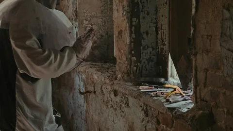 Creepy Clown Looking at His Instruments and Choosing One to Do Something Evil Stock Footage 250947608