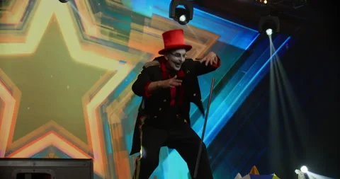 Creepy clown mime showing magic tricks on stage during TV talent show audition Stock Footage 245487397