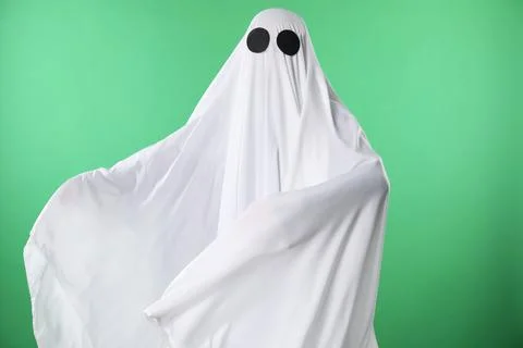 Creepy ghost. Person covered with white sheet on green background 写真素材