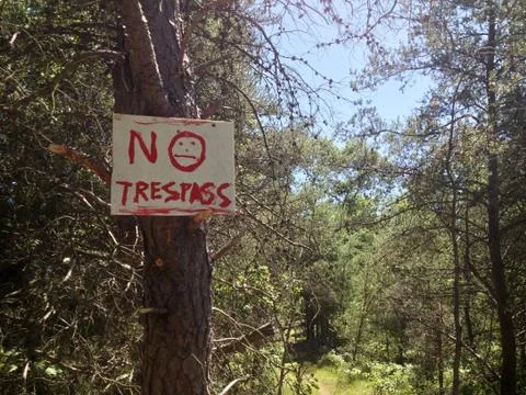 Creepy "No Trespassing" sign in the woods Stock Photos