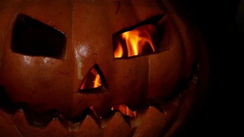 Creepy pumpkin jack-o-lantern face with fire in fireplace in dark. 4k. halloween Video stock 116890581
