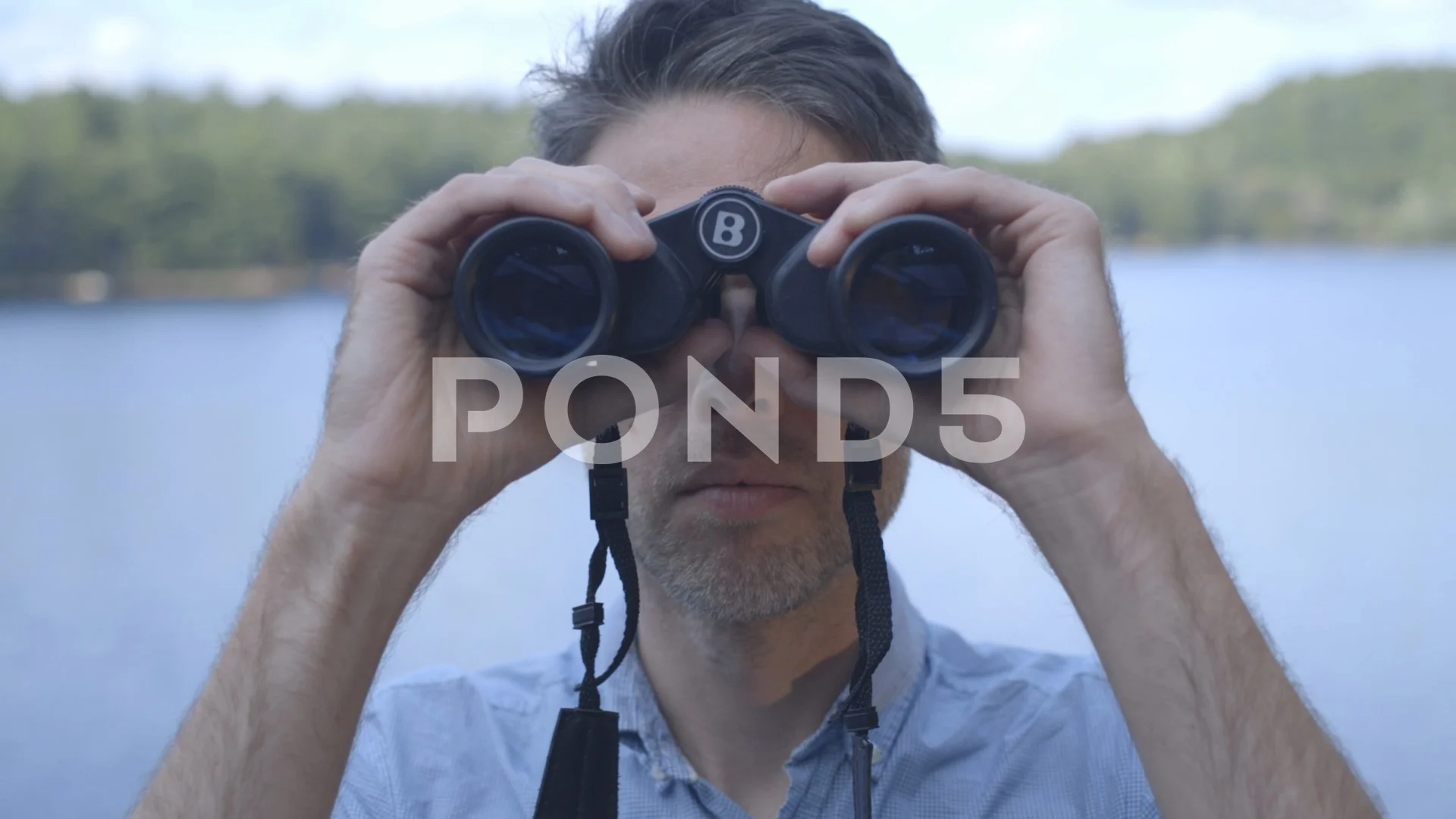 Creepy voyeur looking thru binoculars with lake in background