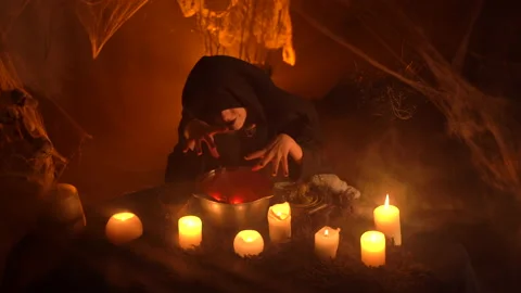 Creepy witch does voodoo black magic ritual near the Witch's cauldron. 스톡 동영상 163386919
