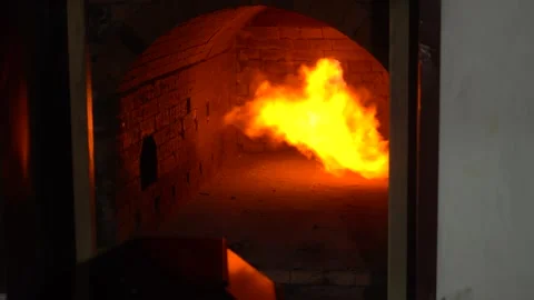 The crematorium door opens, and a fire burns inside. Stock Footage 310210803