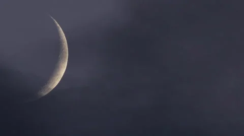 Crescent glowing moon through mystical dusk sky with clouds Stock Footage