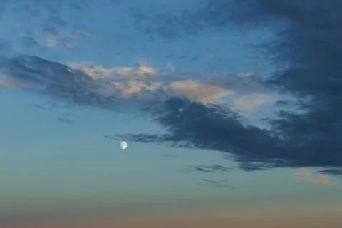 Crescent moon appears in the evening sky Stock Photos
