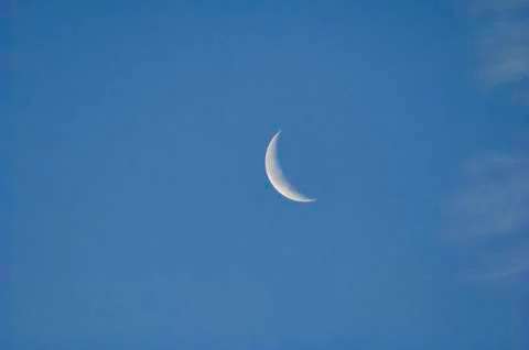 Crescent Moon On A Blue Sky With Clouds Stock Photos