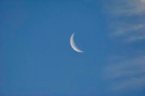 Crescent Moon On A Blue Sky With Clouds Stock Photos