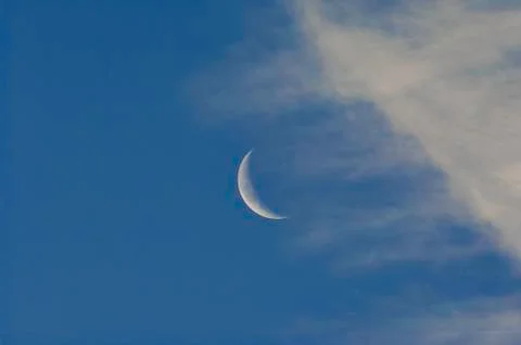 Crescent Moon On A Blue Sky With Clouds Stock Photos