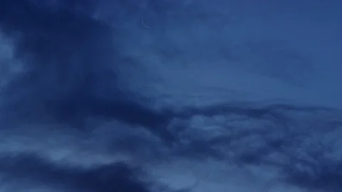 Crescent moon with dark clouds moving thru frame Video stock 102243307