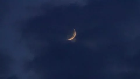 Crescent moon moving through dense clouds at night Video stock 145978434