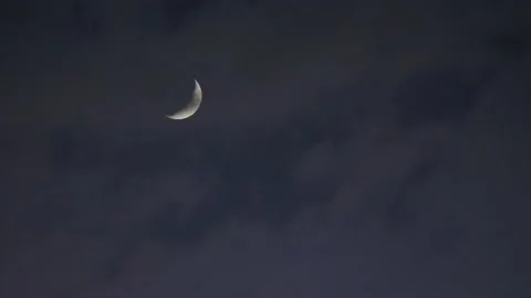 Crescent moon in the night sky. Clouds pass over the moon Stock Footage 135951501