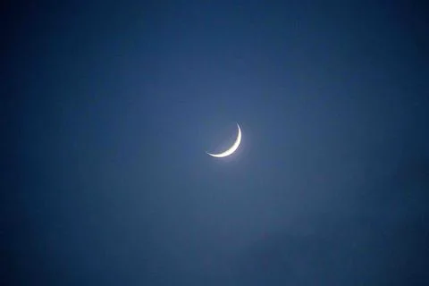 Crescent Moon over the light clouds Stock Photos