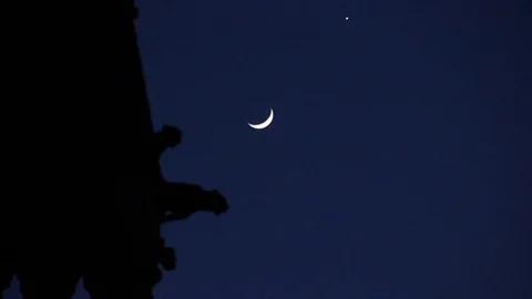 Crescent Moon &amp; planet pass Cathedral, watched by gargoyles Stock Footage 75016159
