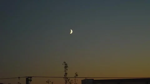 Crescent Moon in Twilight Sky Over City Silhouette at Dusk Stock Footage 345697795