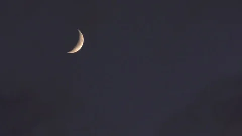 Crescent orange moon with clouds moving reveals brightness Stock Footage 88962342