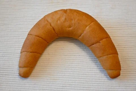 Crescent-shaped bread roll Stock Photos