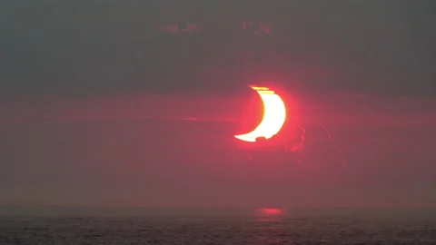Crescent-shaped sun at dawn during a partial solar eclipse at 2x normal Stock Footage 155669906