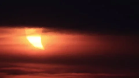 Crescent sun emerging through dark clouds during partial solar eclipse at s.. Stock Footage 342274457