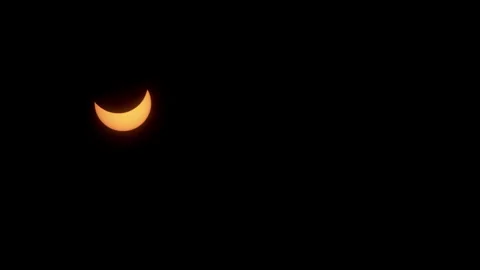 A crescent sun moves across sky during the partial phase of an eclipse. Stock Footage 272406080