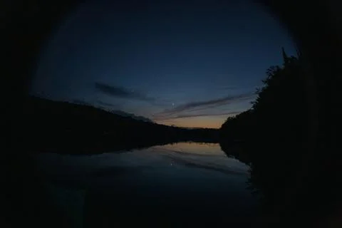 Crescentmoon reflected on sunset lake Stock-Fotos