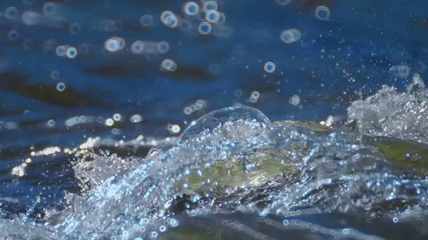 The crests of the waves on the surface of a fast river shine brightly in the sun Stock Footage 313144815