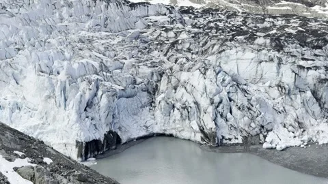 Crevassed ice towers crowd Lamplugh Glacier above a still meltwater pool 動画素材 336220127