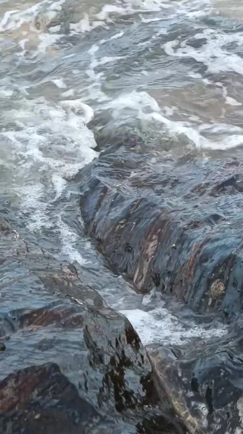 A crevice in the rocks through which water flows from the sea. vertical video Stock Footage 266292519