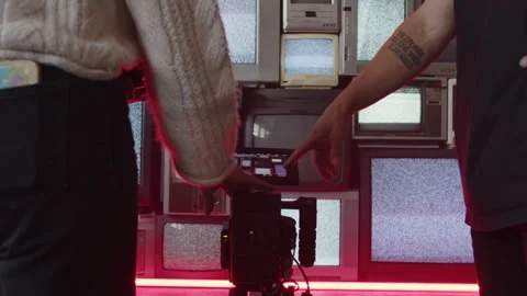 Crew Adjusting Camera Settings In Front Of Static TV's Stock Footage 270326997