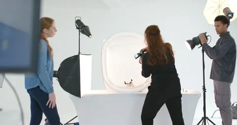 Crew approaching table using camera and tweaking strobe over light tent in Video stock 347742311