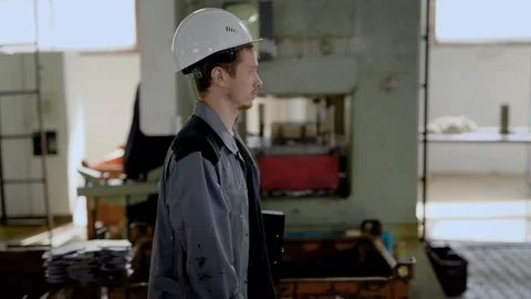 Crew chief passing by workers behind machines, hard manly work on manufactoring Stock-Footage 94999642