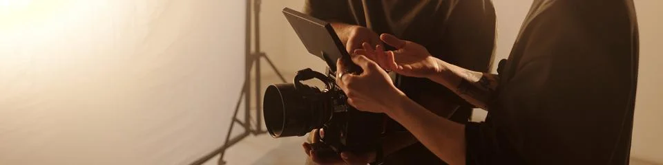 Crew Discussing Camera Settings In Studio Header Image Stock Photos