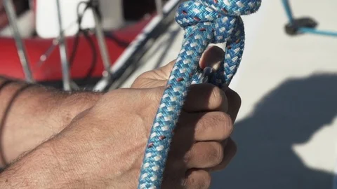 Crew hands attaching halyard to top of main sheet Video stock 99074294