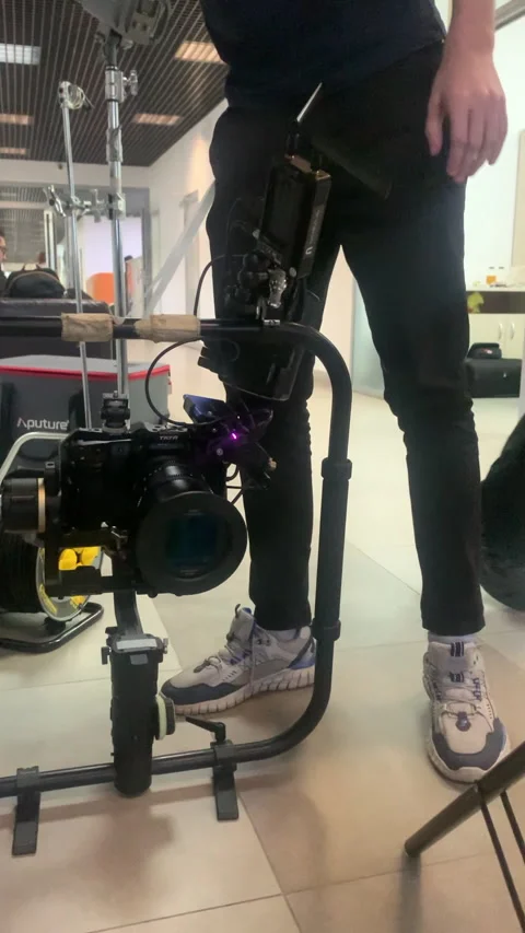 Crew member fastens protective panel onto filming camera Stock Footage 313866605