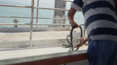 Crew member throwing rope from boat is before docking in marina or port Stock-Footage 325451483