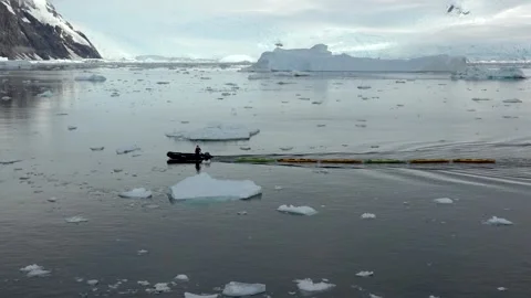 Crew Member Towing Kayaks Through Floating Ice in Andvord Bay, Antarctica Stock Footage 344548735