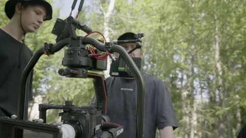 Crew members inspect camera rig before outdoor shoot Stock Footage 308931420