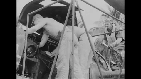 Crew members remove the camera from aircraft as it lands and taken in jeep- 1944 Stock Footage 99786433