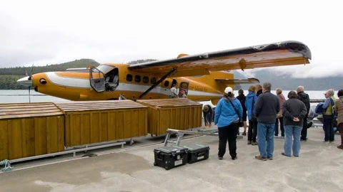 Crew members unloading parcels from the seaplane at port 스톡 동영상 93604102