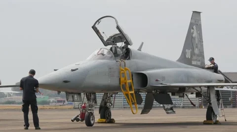 Crew preparing fighter plane as helicopter passes,Ubon Ratchathani,Thailand Stock Footage 58891919