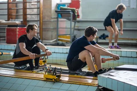 Crew rowing training with coach. Trainer monitors athletes techniques Stock Photos