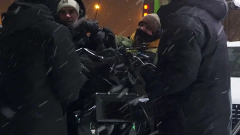 Crew secures camera gear to operator during snowfall Видео 308939877