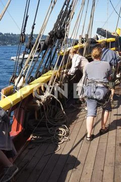 The crew sets the sails of the lady washington Stock Photos