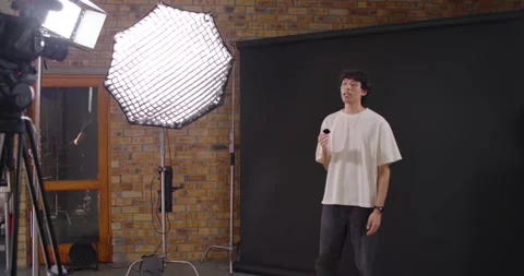 Crew snapping clapper, marking take, Asian presenter stepping into frame and Stock-Footage 347317755