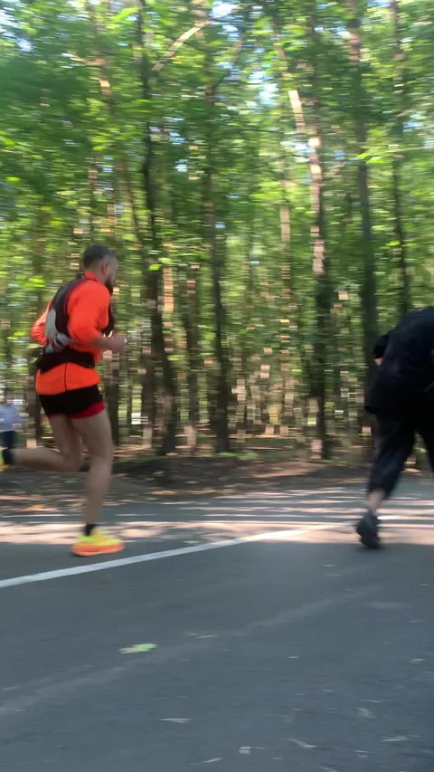 Crew with stabilized rig chases athletic actor through park Видео 313865742
