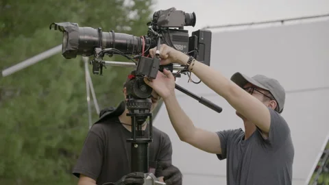 Crew technician adjusts camera settings before take Stock Footage 306553277